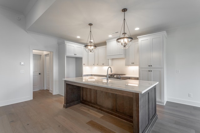 kitchen featuring white cabinetry, hardwood / wood-style floors, and a kitchen island with sink