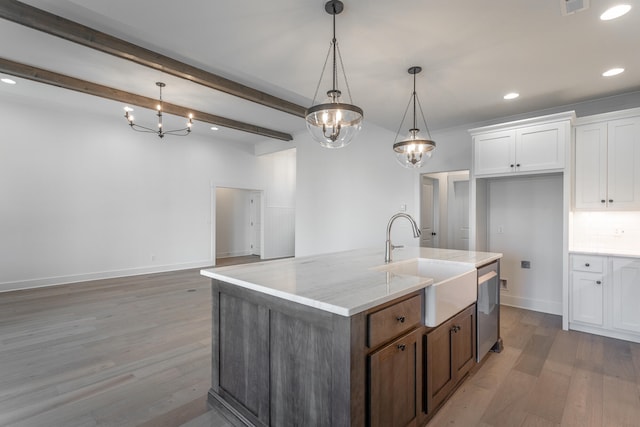 kitchen with white cabinets, decorative light fixtures, beam ceiling, hardwood / wood-style flooring, and sink