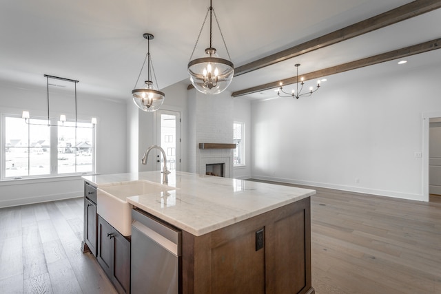 kitchen with a kitchen island with sink, stainless steel dishwasher, hanging light fixtures, and a wealth of natural light