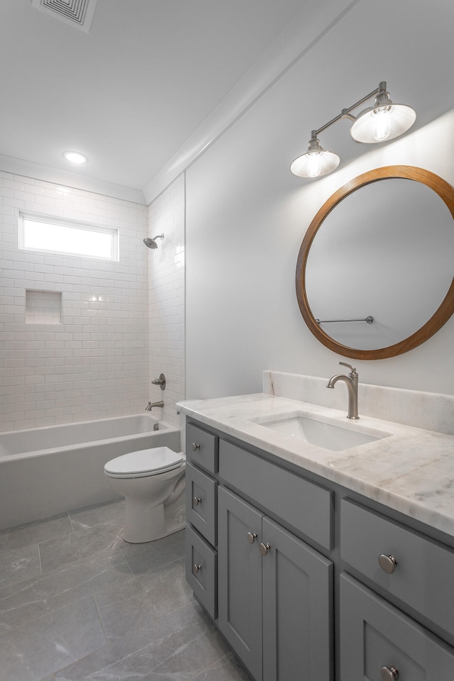 full bathroom featuring vanity, toilet, and tiled shower / bath