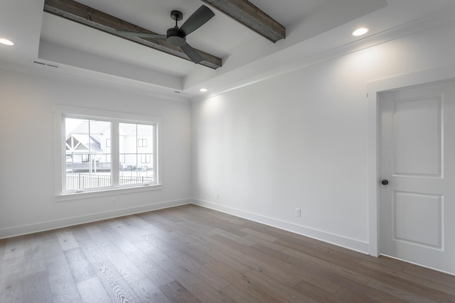 unfurnished room with wood-type flooring, a tray ceiling, beam ceiling, and ceiling fan