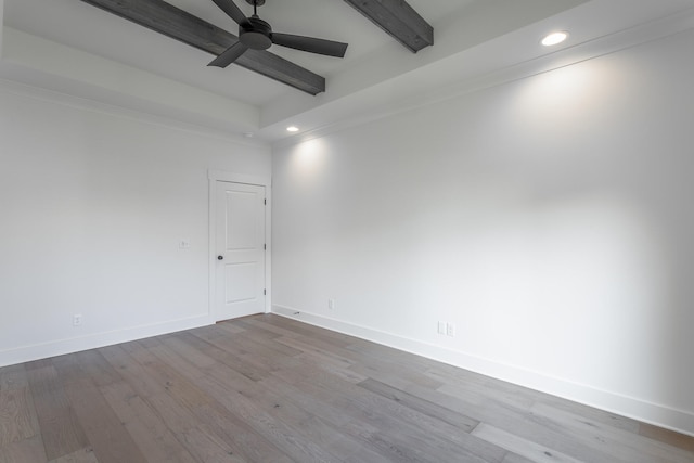 spare room featuring light hardwood / wood-style floors, beamed ceiling, and ceiling fan