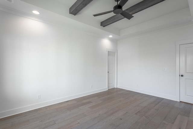 empty room featuring ceiling fan, light wood-type flooring, and beam ceiling