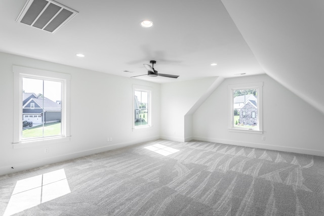 bonus room featuring light carpet, lofted ceiling, and plenty of natural light