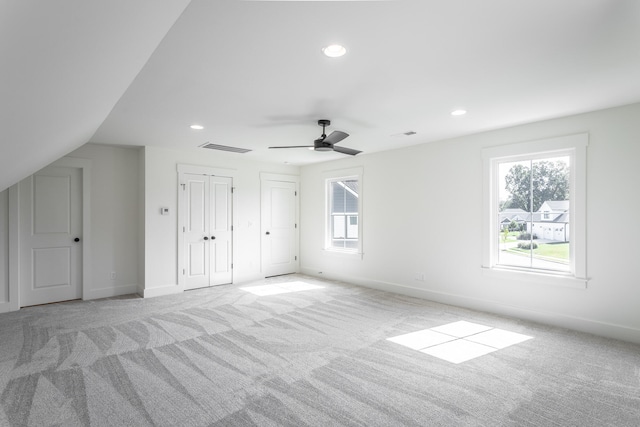 interior space featuring lofted ceiling, ceiling fan, and light colored carpet