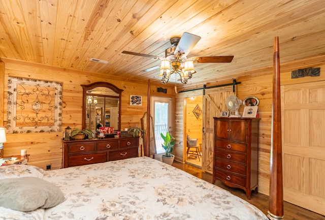 bedroom with wood ceiling, hardwood / wood-style flooring, wood walls, and a barn door