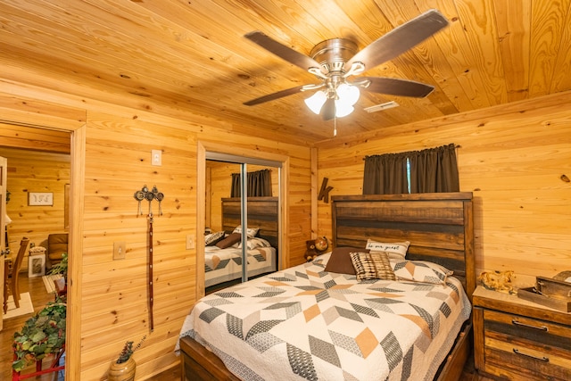 bedroom with ceiling fan, wood walls, a closet, and wooden ceiling