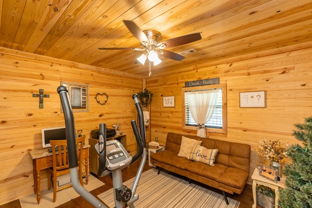 interior space with ceiling fan, wood walls, and wooden ceiling