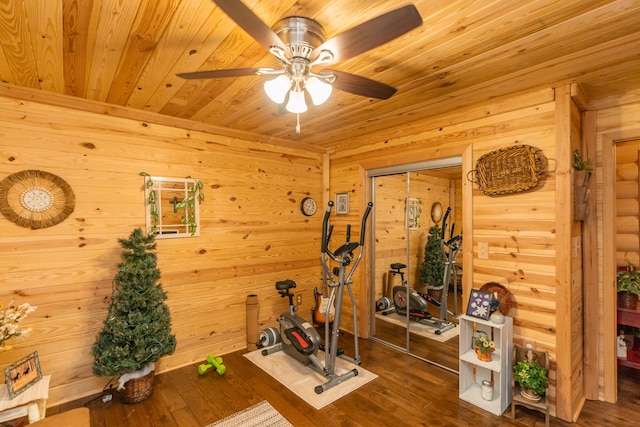 workout area featuring wood ceiling, wood-type flooring, wood walls, and ceiling fan