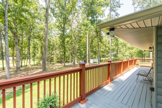 wooden terrace featuring ceiling fan and a yard