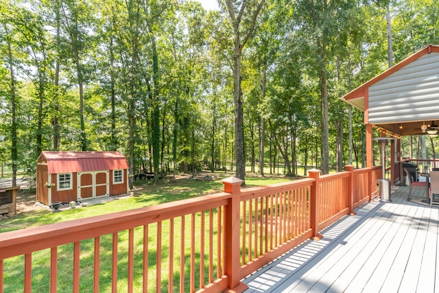 wooden deck featuring a lawn and a shed