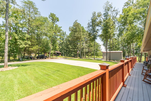 wooden terrace with a yard and a storage unit