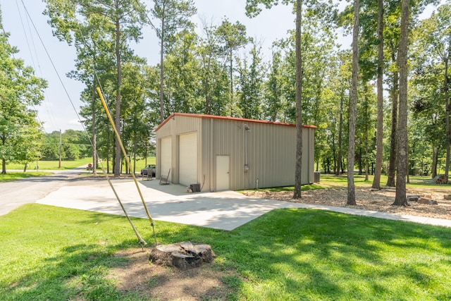 view of outdoor structure with a garage and a lawn