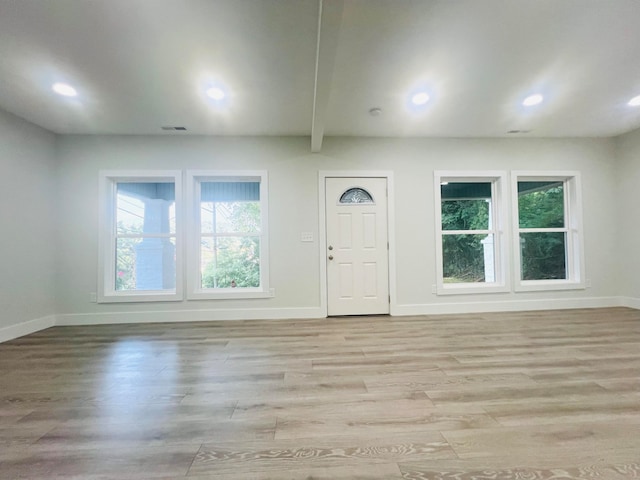 foyer with light hardwood / wood-style flooring and beam ceiling