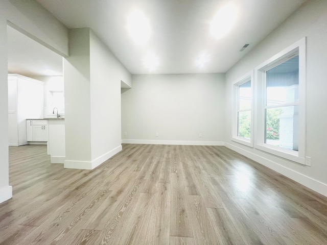 additional living space with sink and light hardwood / wood-style floors