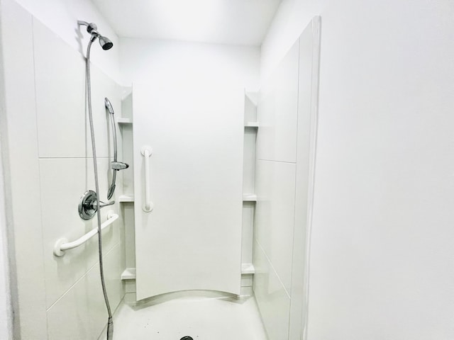 bathroom with a shower and concrete flooring