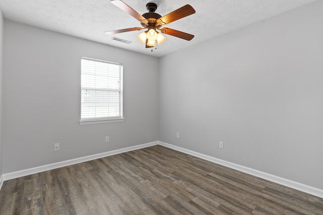 unfurnished room with a textured ceiling, dark wood-type flooring, and ceiling fan