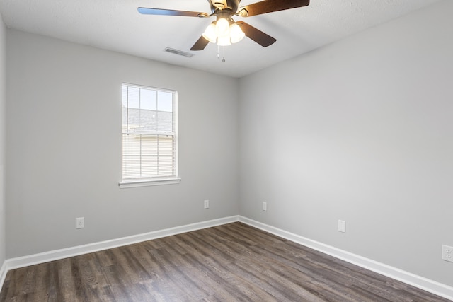 empty room with dark wood-type flooring, ceiling fan, and a textured ceiling