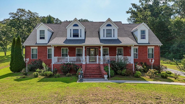 cape cod-style house featuring covered porch and a front lawn