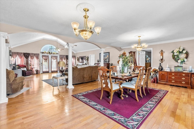 dining area with light hardwood / wood-style floors, vaulted ceiling, ornamental molding, and ornate columns