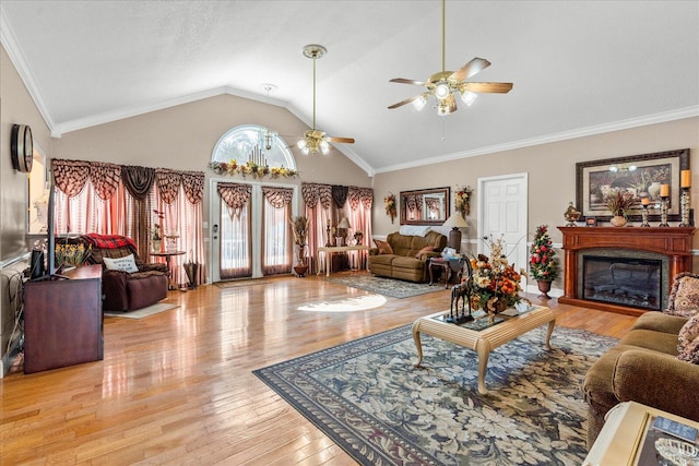 living room featuring lofted ceiling, ceiling fan, ornamental molding, and light hardwood / wood-style flooring