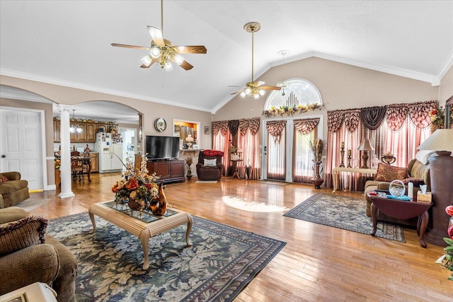 living room with crown molding, ceiling fan, vaulted ceiling, ornate columns, and light hardwood / wood-style floors