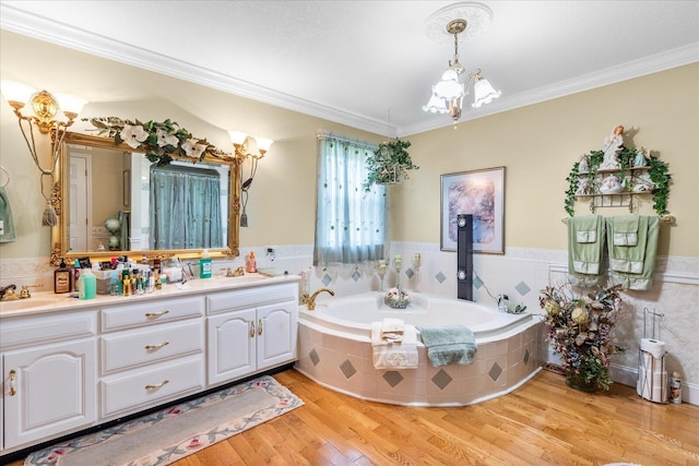 bathroom featuring tiled tub, crown molding, vanity, tile walls, and hardwood / wood-style flooring