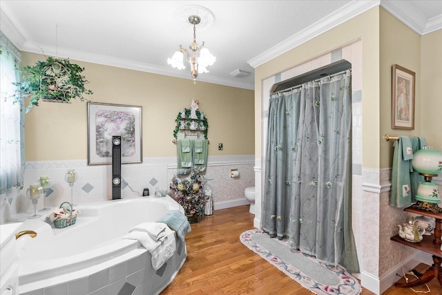 bathroom featuring wood-type flooring, toilet, crown molding, and tiled bath