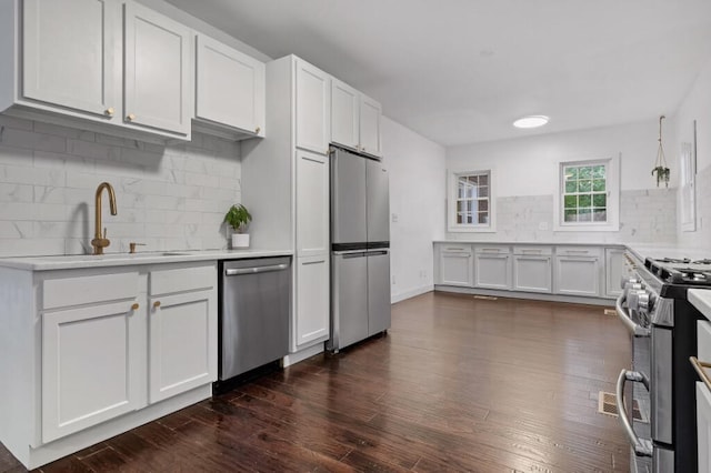 kitchen featuring stainless steel appliances, white cabinets, and dark hardwood / wood-style floors