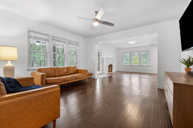 living room with a brick fireplace, ceiling fan, and dark hardwood / wood-style floors