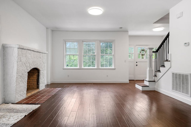 unfurnished living room featuring a fireplace and dark hardwood / wood-style flooring