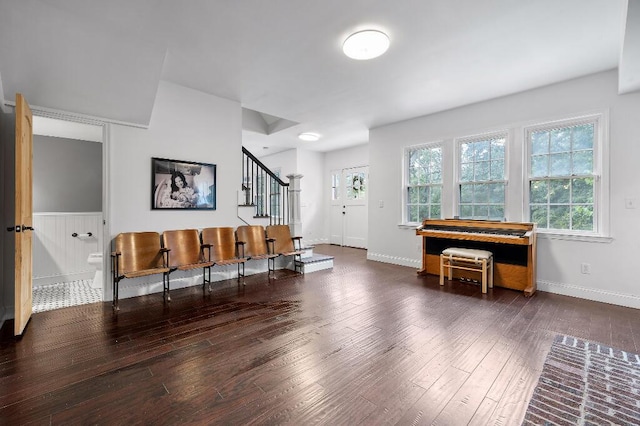 entryway with stairs, a wainscoted wall, wood finished floors, and baseboards