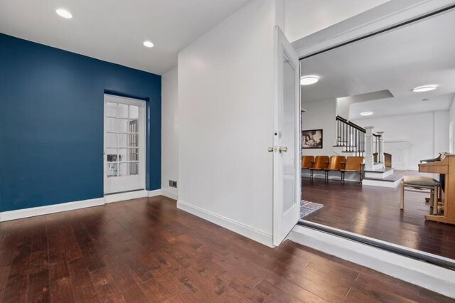 unfurnished room with stairs, recessed lighting, baseboards, and wood-type flooring