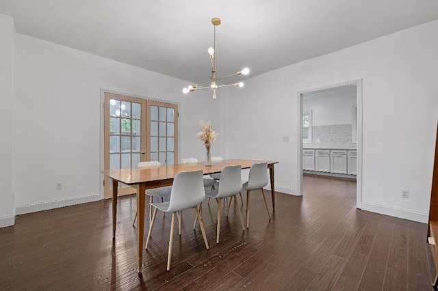 dining space featuring dark wood-type flooring and an inviting chandelier