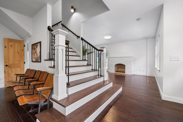 staircase with baseboards, wood finished floors, and a fireplace