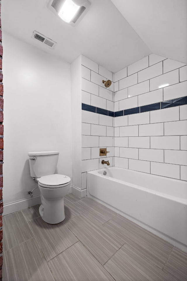 bathroom featuring tiled shower / bath and toilet