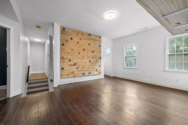 unfurnished room with visible vents, wood-type flooring, and baseboards