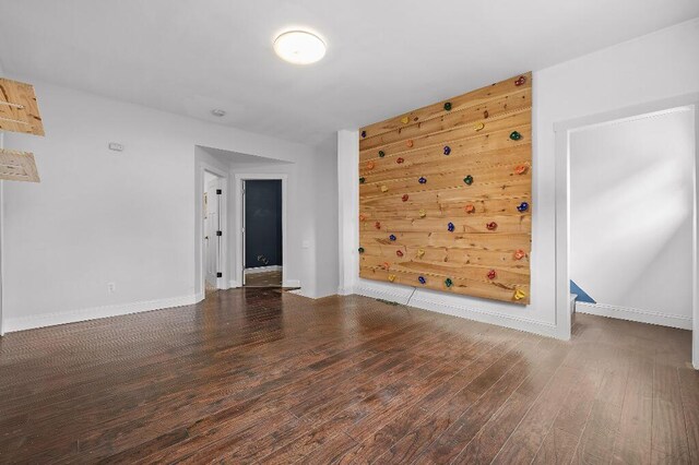 spare room with baseboards and wood finished floors