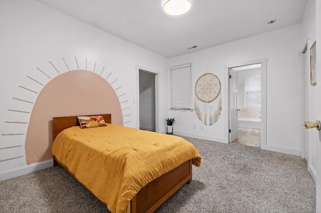 bedroom featuring visible vents, baseboards, carpet, and ensuite bathroom