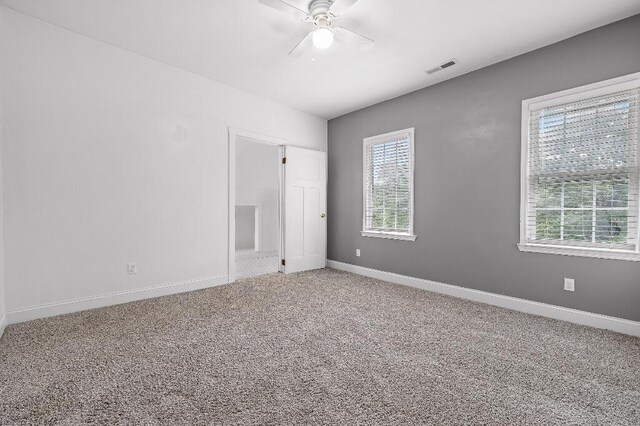 unfurnished room with carpet flooring, ceiling fan, baseboards, and visible vents