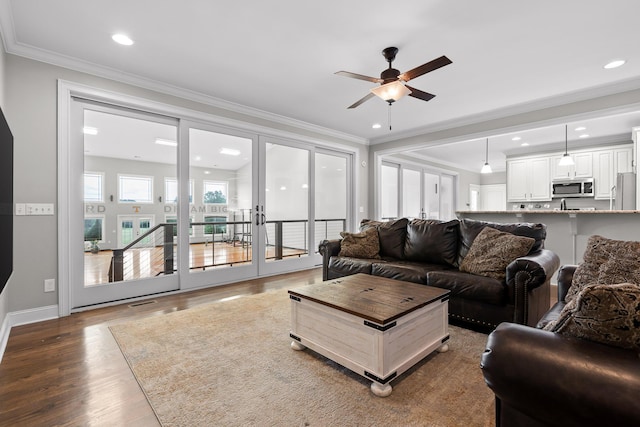 living area featuring recessed lighting, french doors, wood finished floors, and crown molding