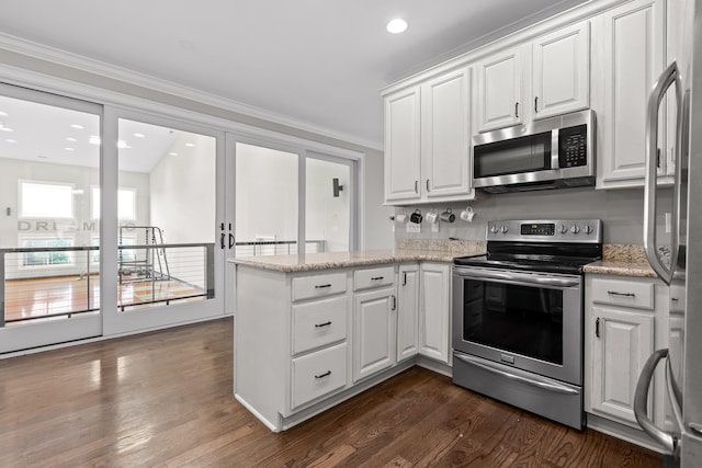 kitchen with dark wood-style floors, white cabinets, stainless steel appliances, and ornamental molding