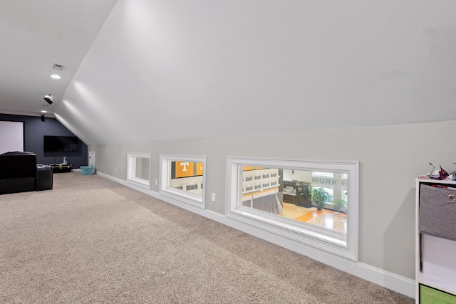 additional living space featuring visible vents, baseboards, lofted ceiling, and carpet