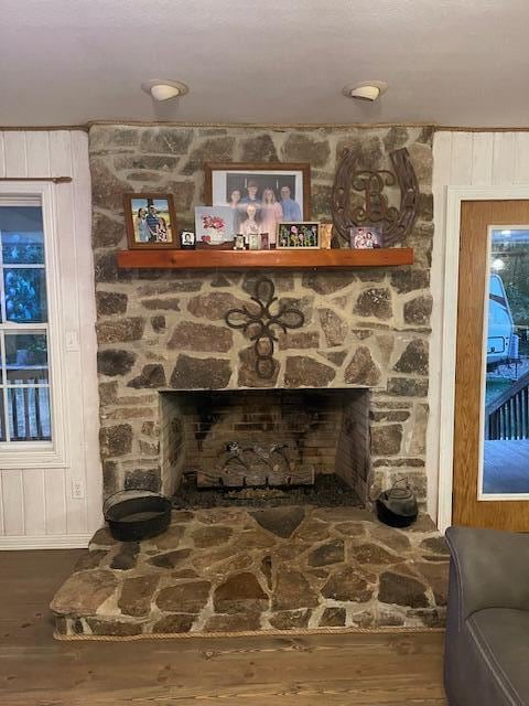 room details featuring wooden walls, hardwood / wood-style flooring, and a fireplace