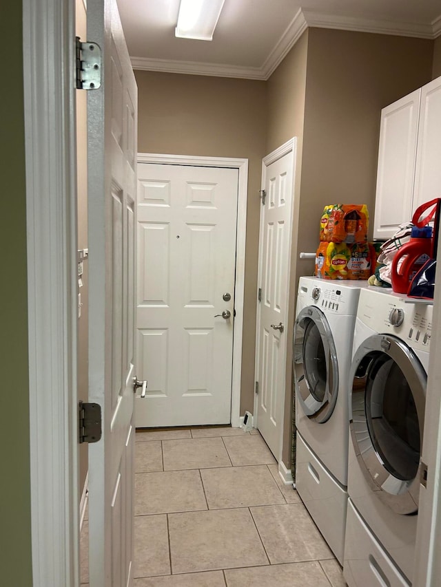 laundry room with crown molding, independent washer and dryer, cabinets, and light tile patterned floors