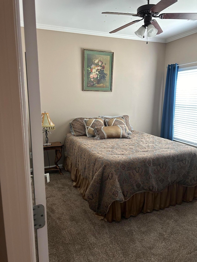 carpeted bedroom featuring ceiling fan and ornamental molding