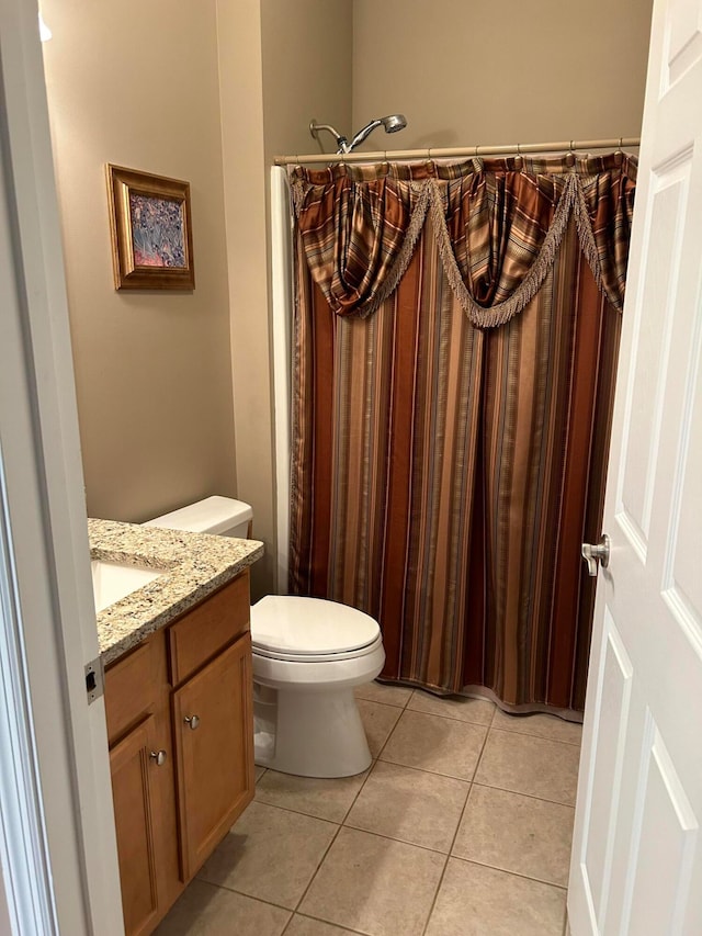 bathroom with vanity, toilet, curtained shower, and tile patterned flooring