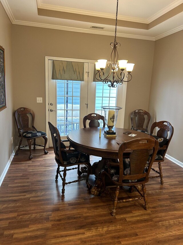 dining room featuring crown molding, dark hardwood / wood-style floors, and an inviting chandelier