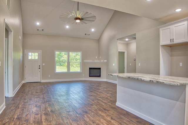 unfurnished living room featuring high vaulted ceiling and dark hardwood / wood-style flooring