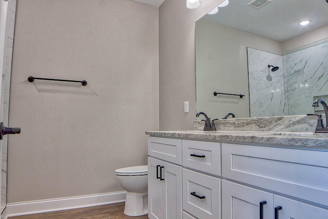 bathroom featuring vanity, hardwood / wood-style floors, toilet, and walk in shower